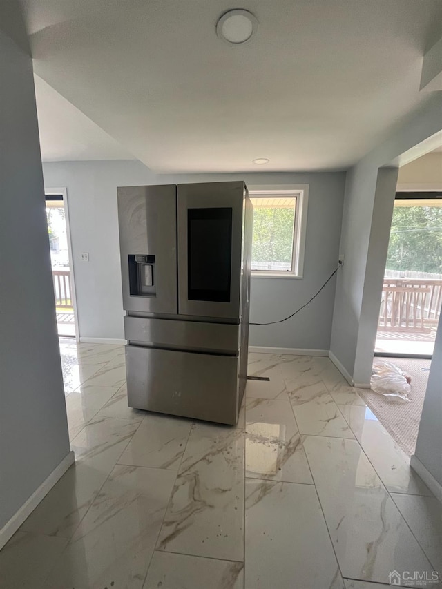 kitchen featuring stainless steel fridge with ice dispenser and a wealth of natural light