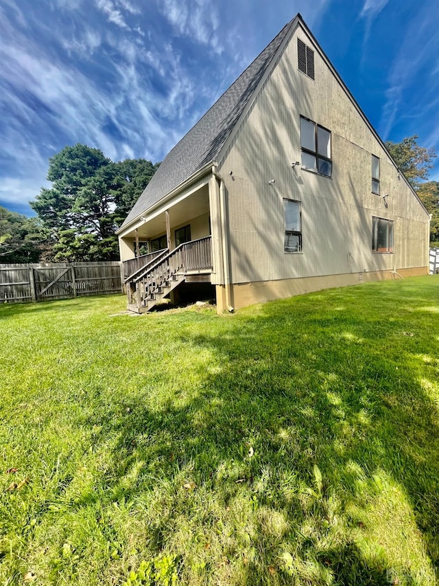 rear view of property featuring a lawn