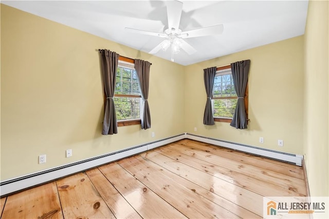 spare room featuring wood-type flooring, a baseboard radiator, and ceiling fan
