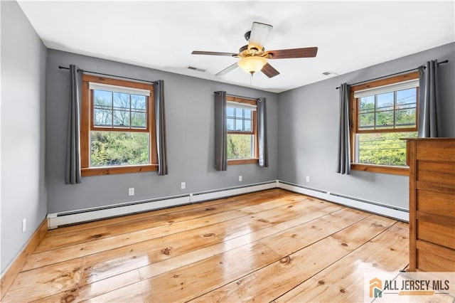 spare room featuring hardwood / wood-style flooring, a baseboard radiator, ceiling fan, and baseboards