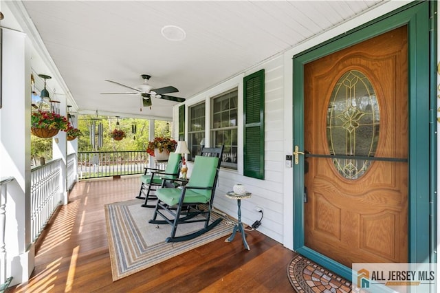 view of exterior entry with covered porch and ceiling fan