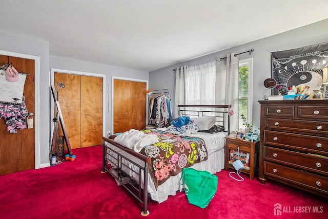 bedroom with carpet floors and two closets