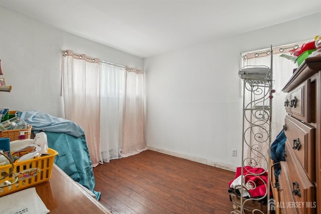 bedroom with wood finished floors and baseboards