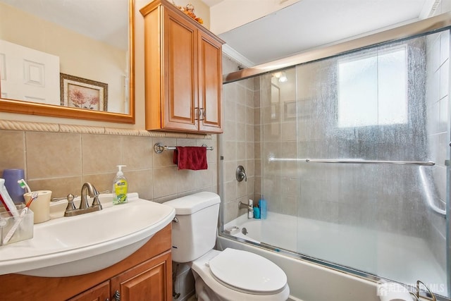 full bathroom featuring bath / shower combo with glass door, toilet, vanity, and decorative backsplash
