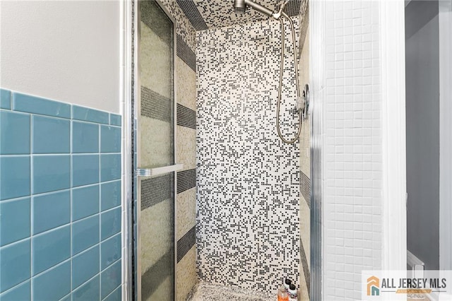 full bathroom with a stall shower and tile walls