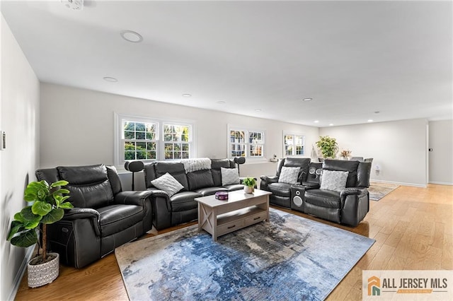 living area with recessed lighting, baseboards, and light wood-style floors