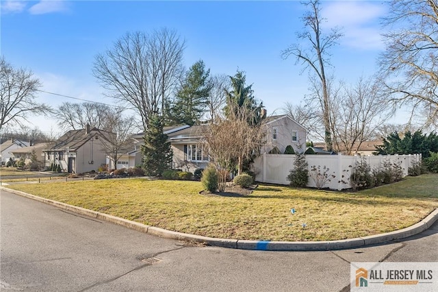 view of front of house featuring a residential view, a front yard, and fence