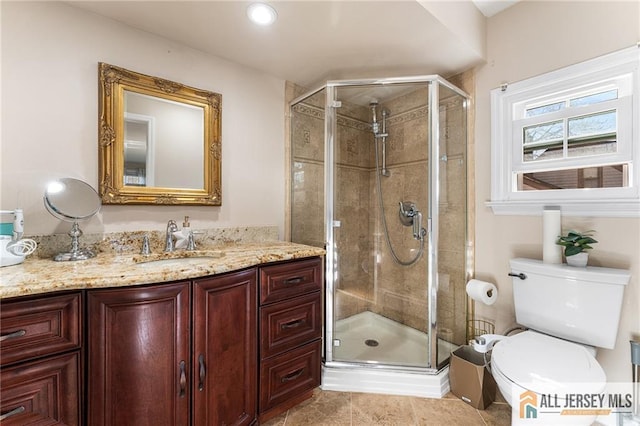 bathroom featuring tile patterned flooring, toilet, a stall shower, and vanity