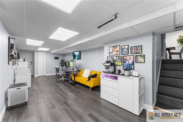 office space with a drop ceiling, baseboards, and dark wood-style flooring