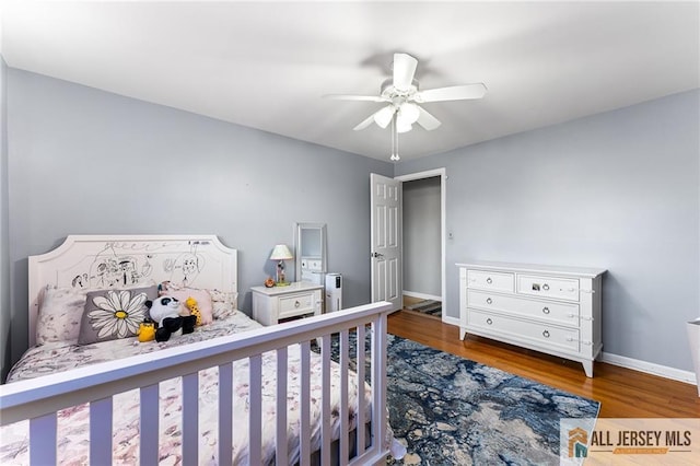 bedroom with a ceiling fan, baseboards, and wood finished floors