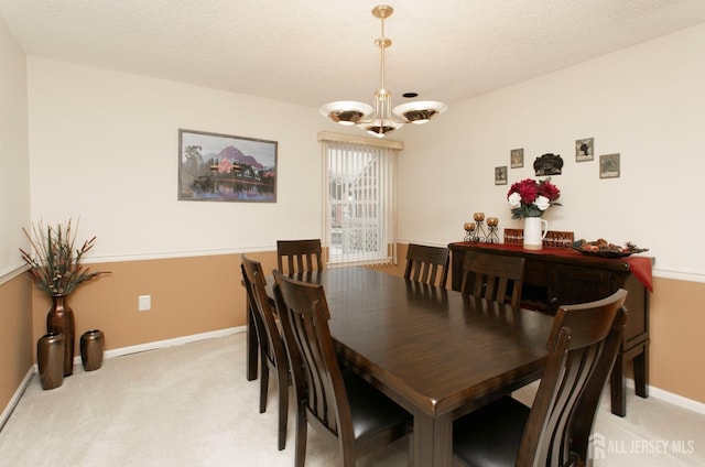 dining area featuring a chandelier, light carpet, and a textured ceiling