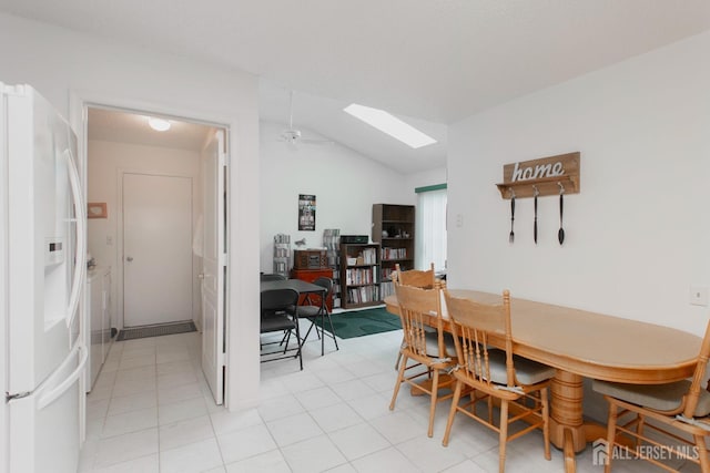 dining area with vaulted ceiling with skylight and ceiling fan