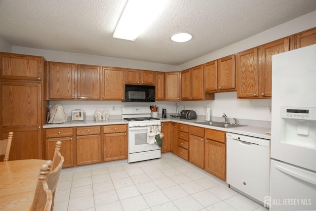 kitchen with sink, white appliances, and a textured ceiling