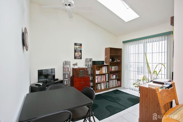 tiled home office featuring ceiling fan and vaulted ceiling with skylight