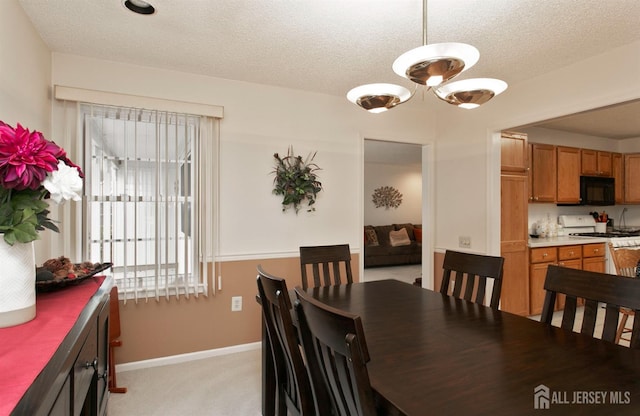 dining room with light colored carpet and a textured ceiling