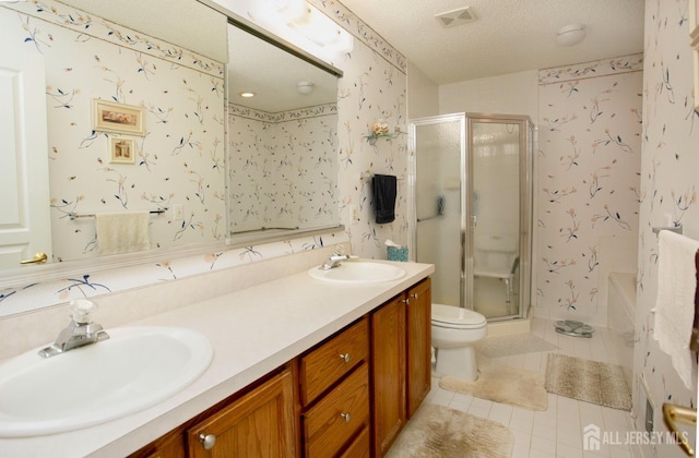 bathroom featuring tile patterned floors, toilet, a textured ceiling, vanity, and a shower with door