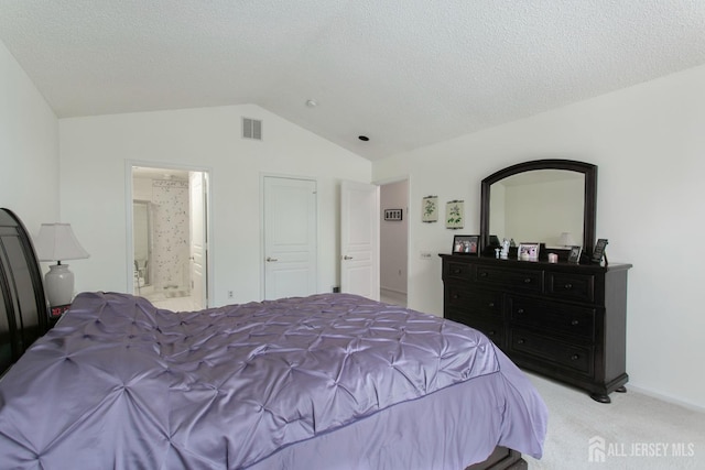 carpeted bedroom with ensuite bathroom, vaulted ceiling, and a textured ceiling