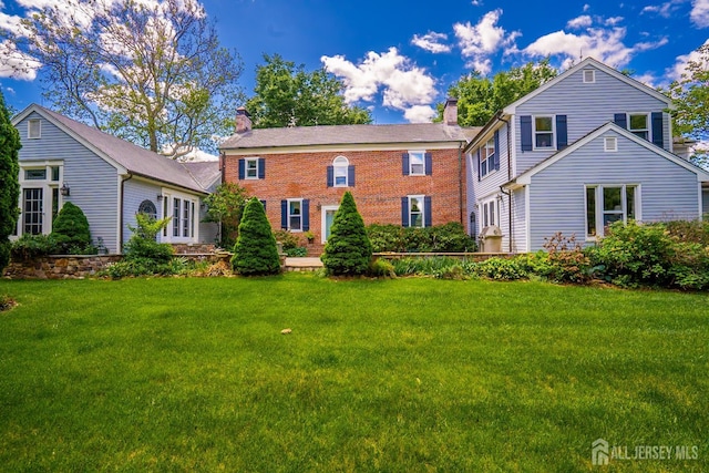7 Finch Ct, West Windsor, NJ 08550 - view of front of house with a chimney, a front yard, and brick siding