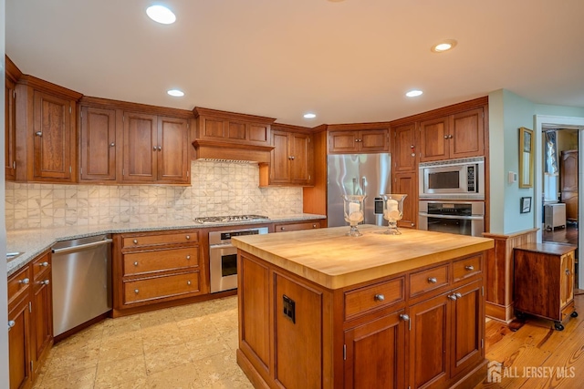 7 Finch Ct, West Windsor, NJ 08550 - kitchen featuring appliances with stainless steel finishes, wood counters, brown cabinetry, a center island, and recessed lighting