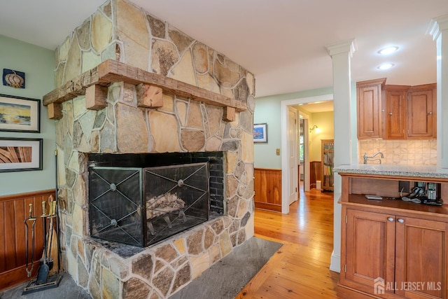 7 Finch Ct, West Windsor, NJ 08550 - living room featuring light wood-style flooring, a wainscoted wall, a fireplace, and wood walls