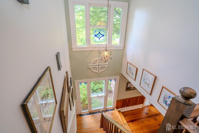 7 Finch Ct, West Windsor, NJ 08550 - stairway with a baseboard heating unit, wood-type flooring, healthy amount of natural light, a high ceiling, and wainscoting