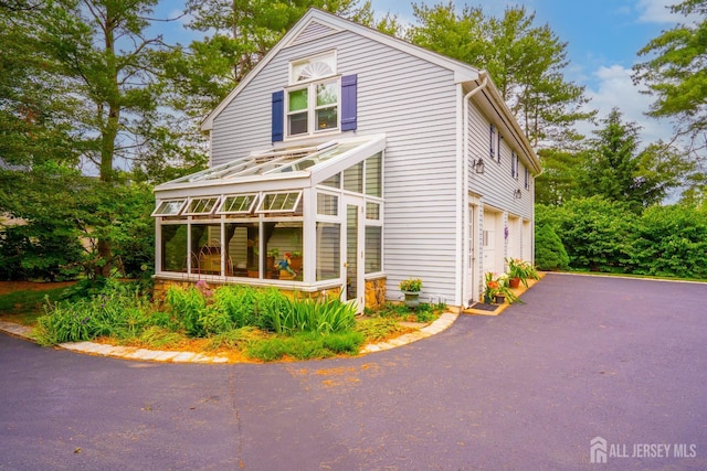 7 Finch Ct, West Windsor, NJ 08550 - view of side of property with asphalt driveway, a garage, and a sunroom