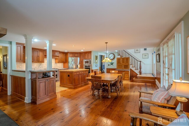 7 Finch Ct, West Windsor, NJ 08550 - dining room featuring light wood finished floors, stairway, recessed lighting, healthy amount of natural light, and ornate columns