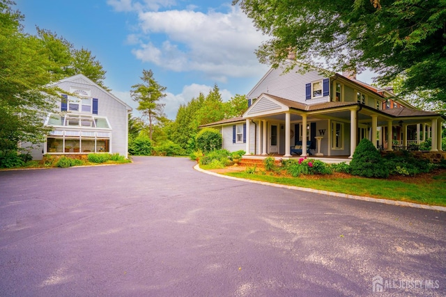 7 Finch Ct, West Windsor, NJ 08550 - view of side of property featuring covered porch, a chimney, and asphalt driveway