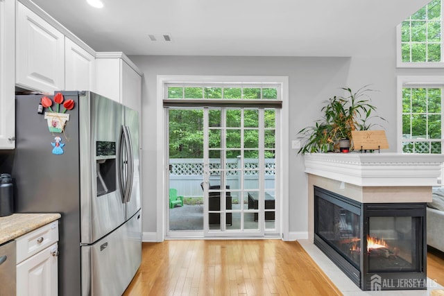 22 Daffodil Way, Old Bridge, NJ 08857 - kitchen featuring stainless steel fridge with ice dispenser, light wood-type flooring, white cabinetry, a multi sided fireplace, and recessed lighting