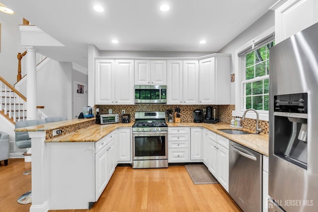 22 Daffodil Way, Old Bridge, NJ 08857 - kitchen featuring appliances with stainless steel finishes, a peninsula, light wood finished floors, white cabinetry, and recessed lighting