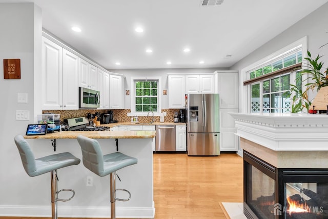 22 Daffodil Way, Old Bridge, NJ 08857 - kitchen featuring stainless steel appliances, backsplash, white cabinetry, a peninsula, and a kitchen breakfast bar