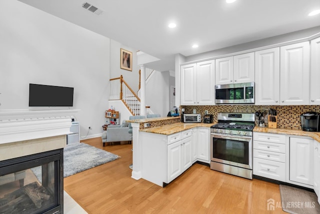 22 Daffodil Way, Old Bridge, NJ 08857 - kitchen with a peninsula, appliances with stainless steel finishes, backsplash, light wood-style flooring, and recessed lighting