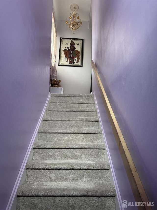 staircase featuring a notable chandelier