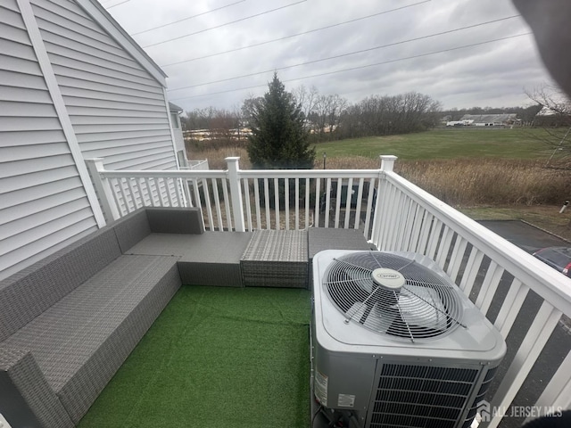 view of wooden balcony with central AC unit, a deck, and outdoor lounge area
