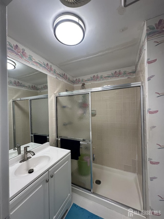 full bath featuring vanity, tile patterned flooring, and a stall shower