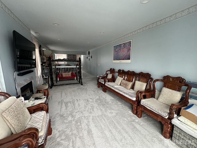 living area featuring carpet flooring, a fireplace, and ornamental molding