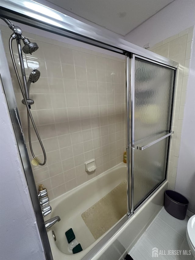 full bathroom with toilet, tile patterned floors, and combined bath / shower with glass door