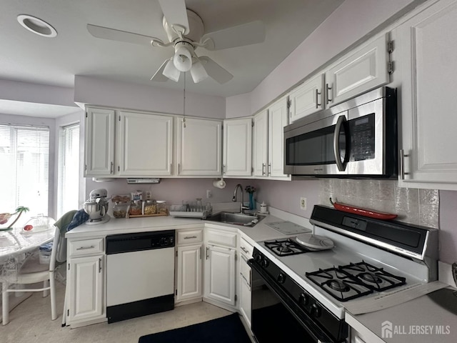kitchen featuring white appliances, white cabinets, and a sink