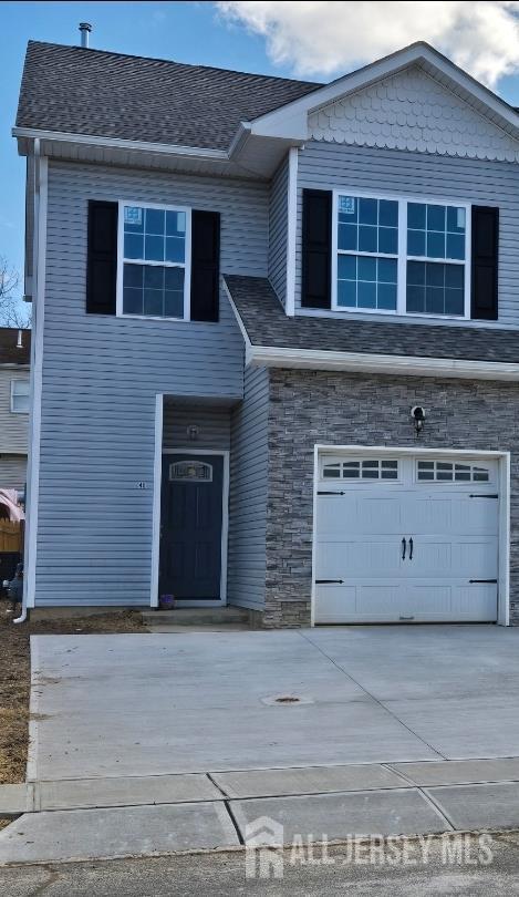 40 J Russel Smith Rd, Lawrence, NJ 08648 - view of front of house featuring a garage, stone siding, concrete driveway, and a shingled roof