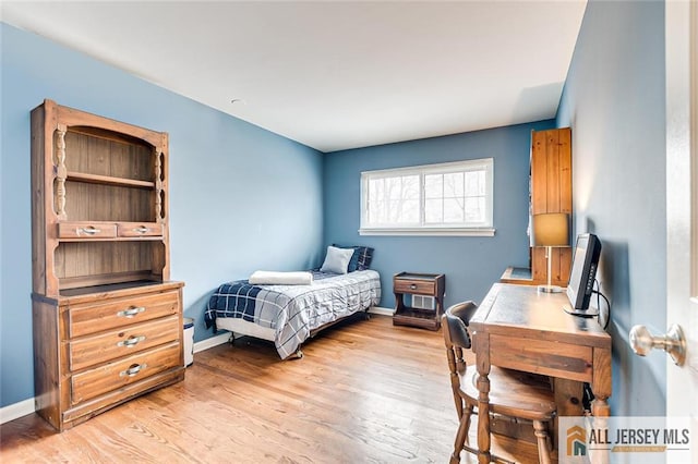 bedroom with baseboards and light wood-type flooring