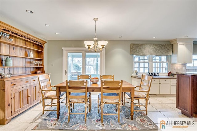 dining space featuring an inviting chandelier, light tile patterned flooring, and a healthy amount of sunlight