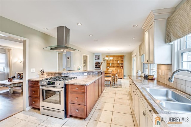kitchen featuring stainless steel range with gas cooktop, a sink, extractor fan, a chandelier, and light tile patterned floors