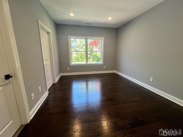 empty room with dark hardwood / wood-style floors