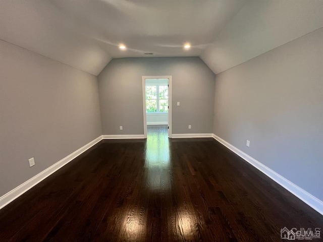 bonus room with dark wood-type flooring and lofted ceiling