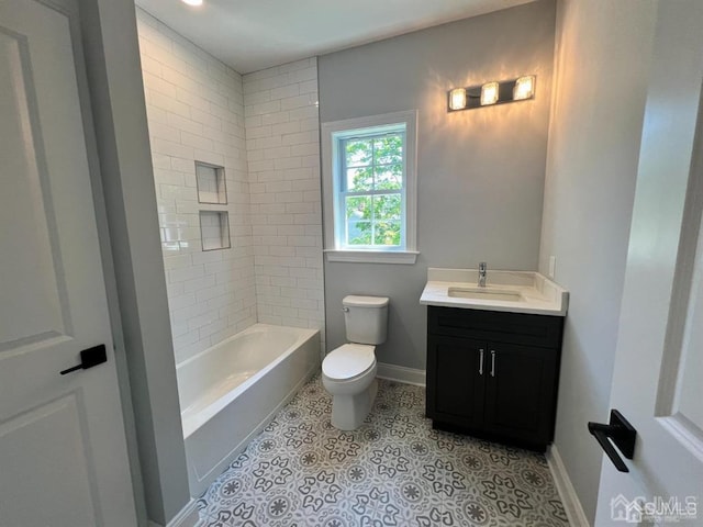 full bathroom with tile patterned floors, vanity, tiled shower / bath, and toilet