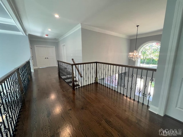 corridor featuring dark wood-type flooring, crown molding, and a chandelier