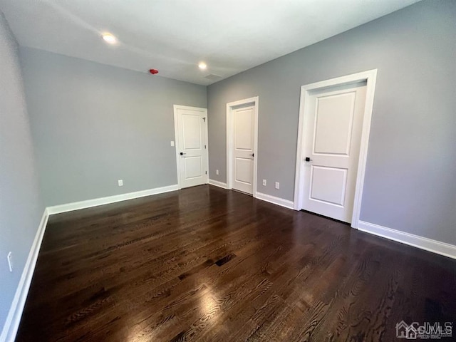 unfurnished bedroom with dark wood-type flooring