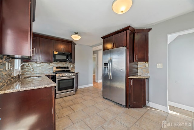 48 Columbus Ave, Edison, NJ 07008 - kitchen featuring stainless steel appliances, a sink, decorative backsplash, light stone counters, and baseboards