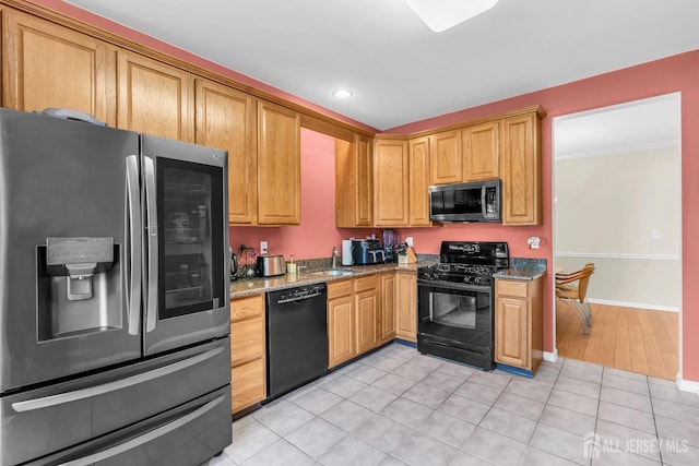 kitchen featuring black appliances, light stone countertops, and light tile patterned flooring