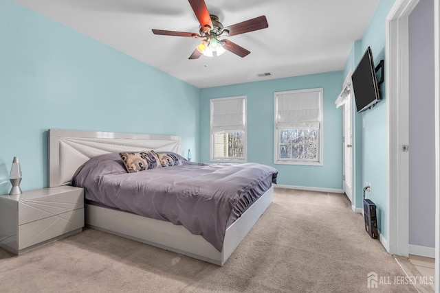 bedroom with light carpet, baseboards, and ceiling fan